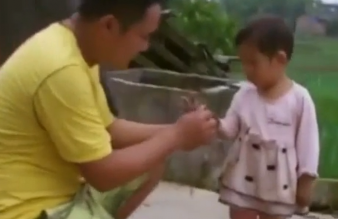 В Китае отец играет с больной дочерью в могиле, подготовленной для неё